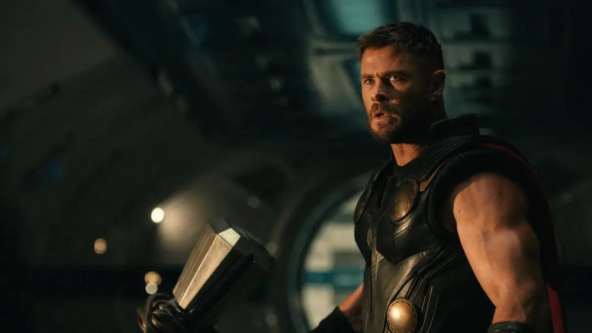 Thor (Chris Hemsworth), son marteau à la main, dans un couloir sombre